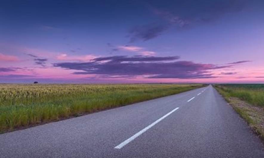 A country road in a purple sunset