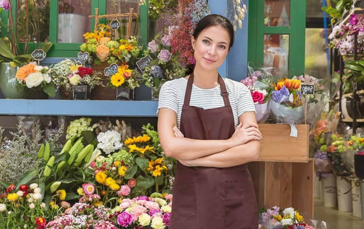 Flower shop owner in front of her shop covered by commercial property insurance