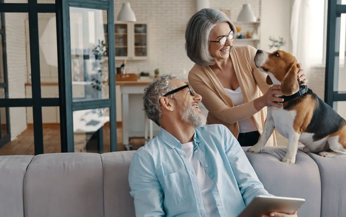 Pet owners and dog protected by pet insurance for AARP members