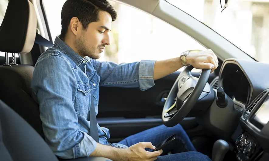 A driver looking down at their cell phone