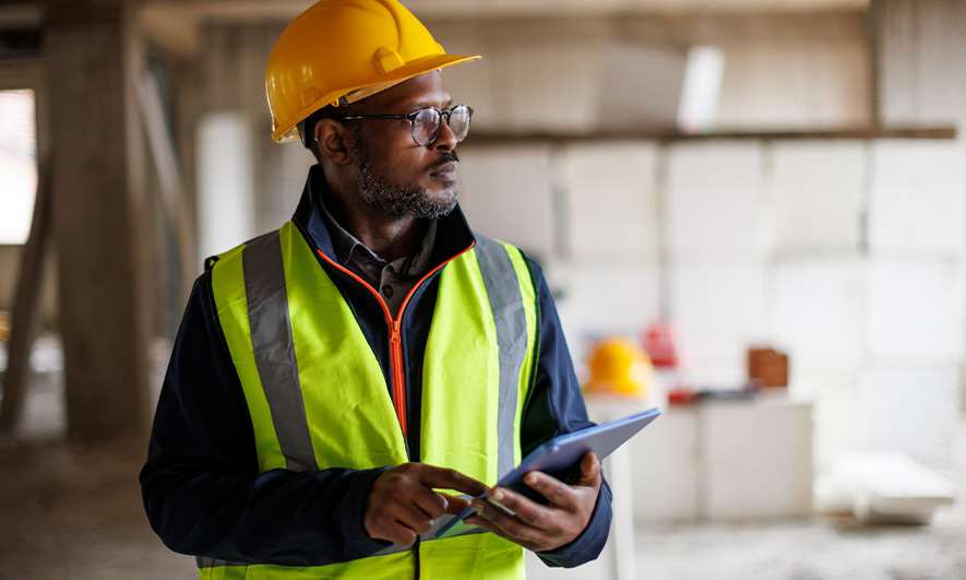 Construction supervisor monitoring work with a tablet.