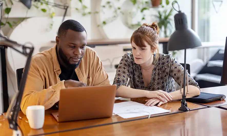 A man and woman working at a desk