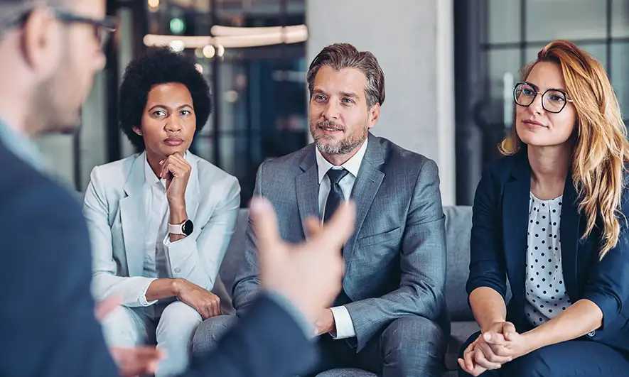 People in a business meeting listening to a man speak