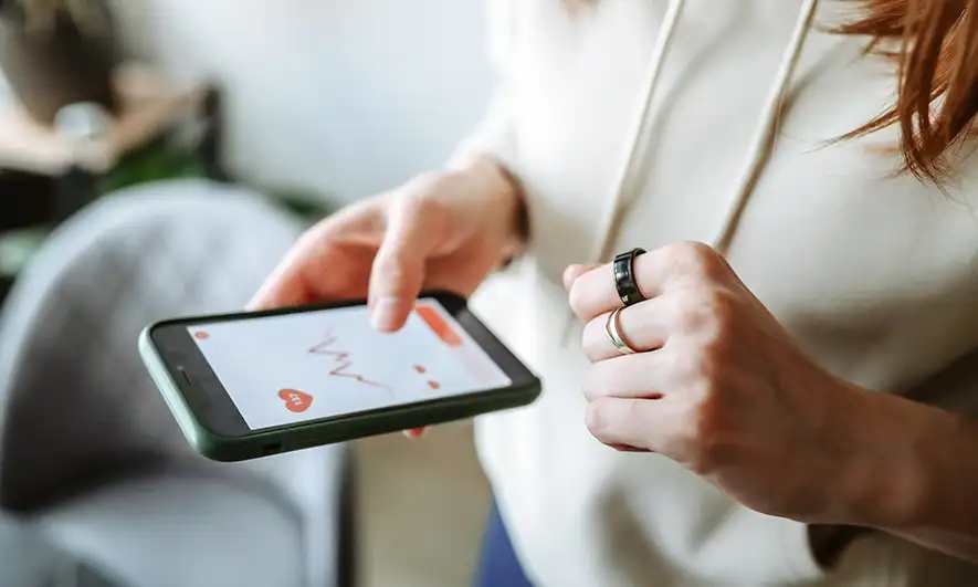 Person holding a smartphone displaying in a line graph, interacting with the screen.