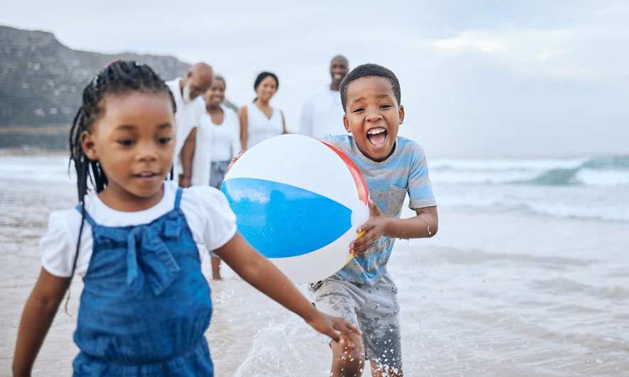 family playing on beach