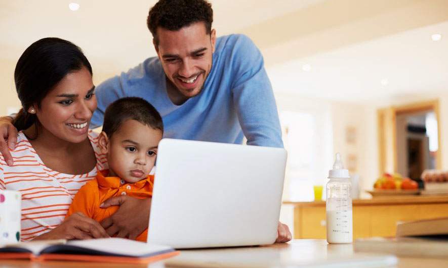 mom dad son looking at computer