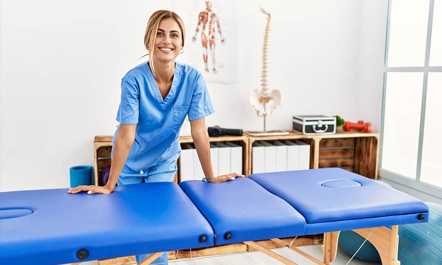 a massage therapist with insurance coverage standing over a massage table