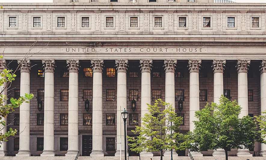 Front view of a United States courthouse with tall white columns and engraved stone facade.