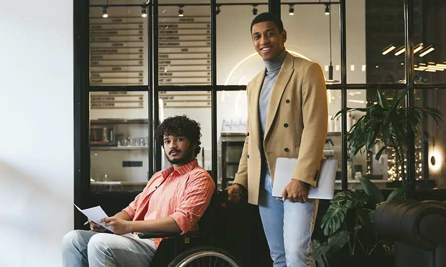 Two employees in an office, one using a wheelchair