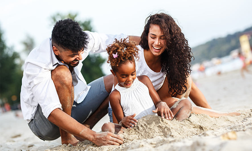 A family plays together on a beach