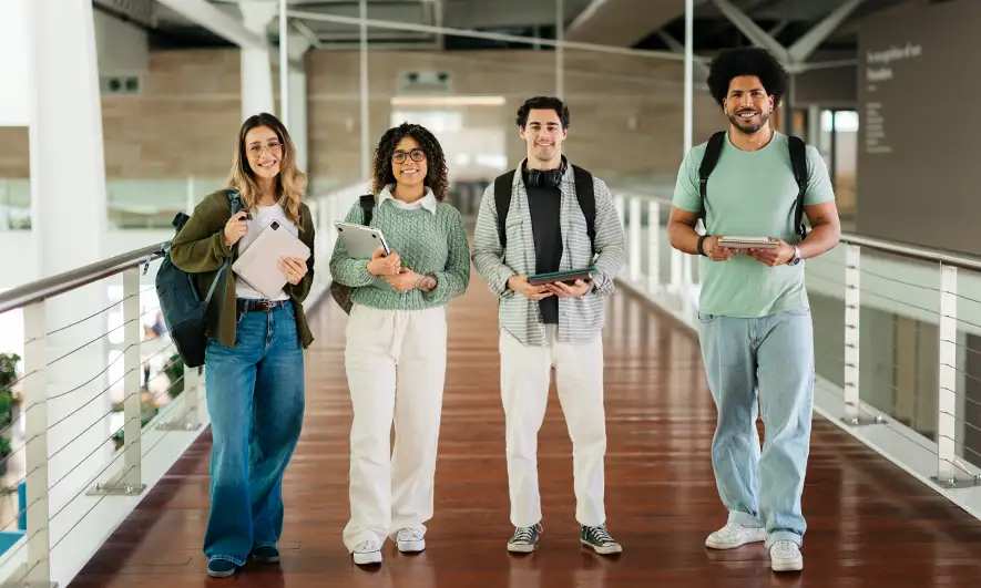 Four students stand in a school hallway