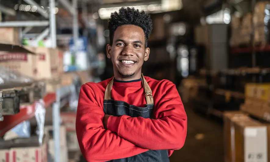 male small business owner happy to know how much does workers comp insurance cost