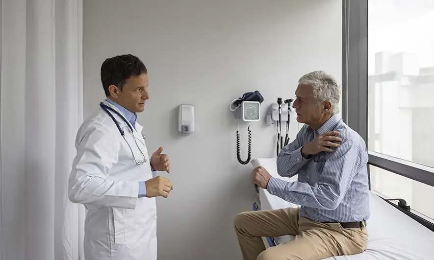 doctor examines male covered by personal injury protection from The Hartford