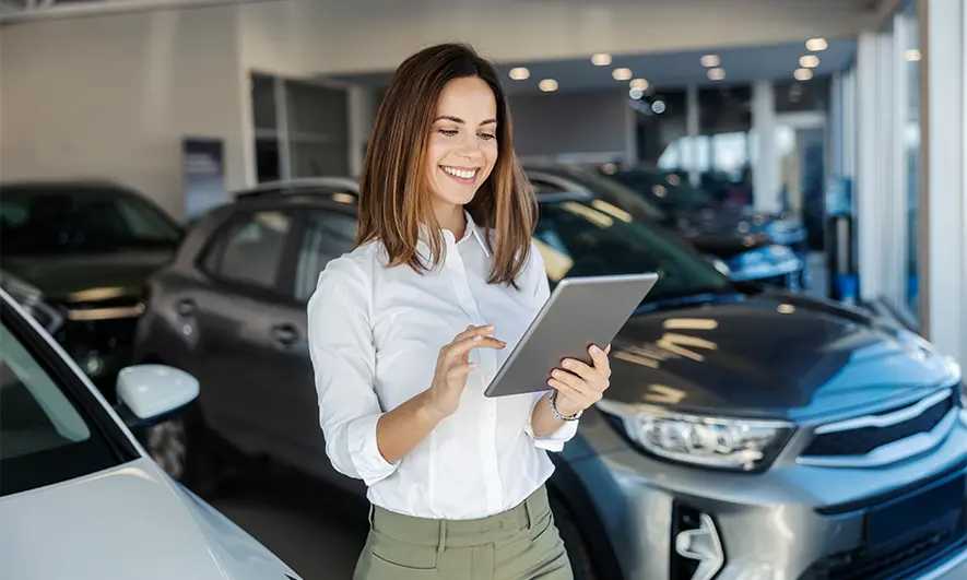 business owner happy to do her job after getting auto dealership insurance