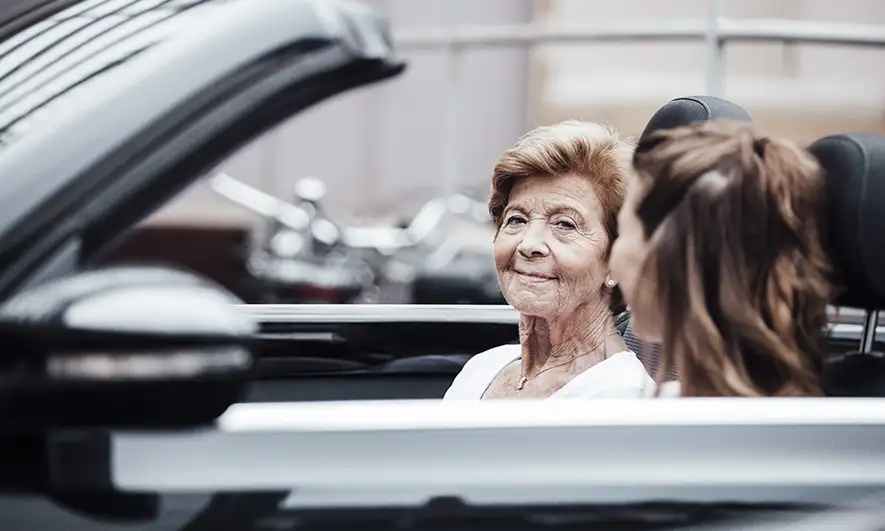 females in car discuss changing car insurance