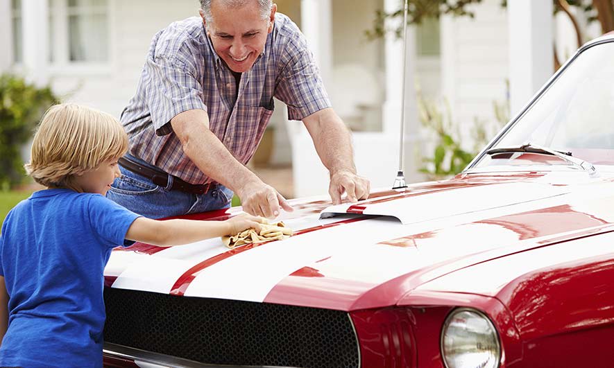 classic car owner enjoys time with his grandson knowing he is protected by collector car insurance
