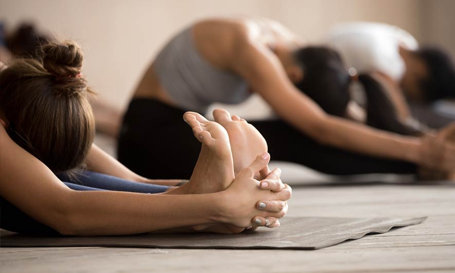 Students stretching in a class protected by yoga and pilates instructor insurance
