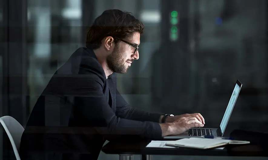 A man working on his laptop at night
