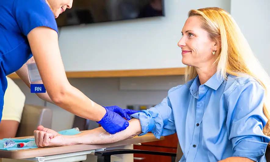 business owner happy to do her job after getting a phlebotomist insurance quote
