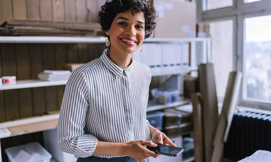 happy female small business owner protected by The Hartford