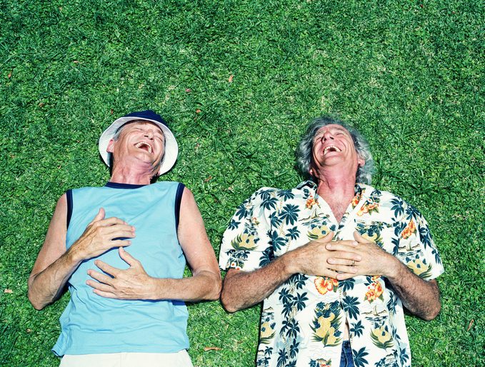 two men laying on the ground laughing